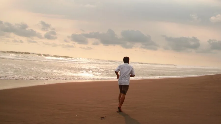 Active person running outdoors wearing wireless headphones during workout session