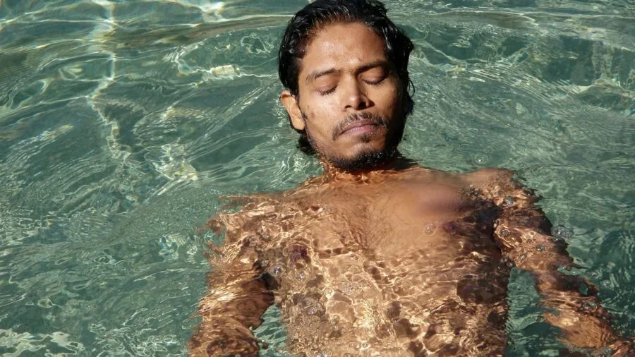 Active person swimming in outdoor water, demonstrating water-resistant watch durability in real conditions
