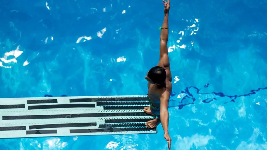 Athlete in pool glancing at wrist during swim training session