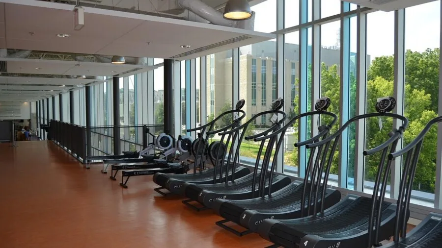 Athlete wearing wireless headphones during indoor workout session at modern gym facility