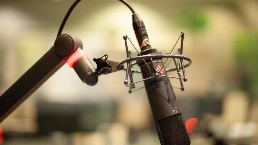 Audio engineer working at mixing console in professional studio with headphones