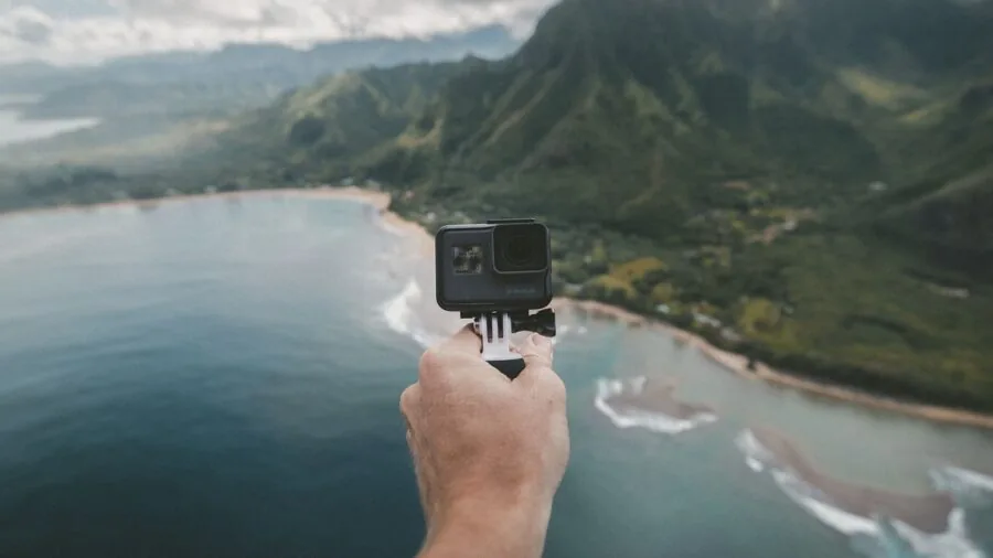 Casual photographer with camera gear hiking through scenic mountain landscape during golden hour