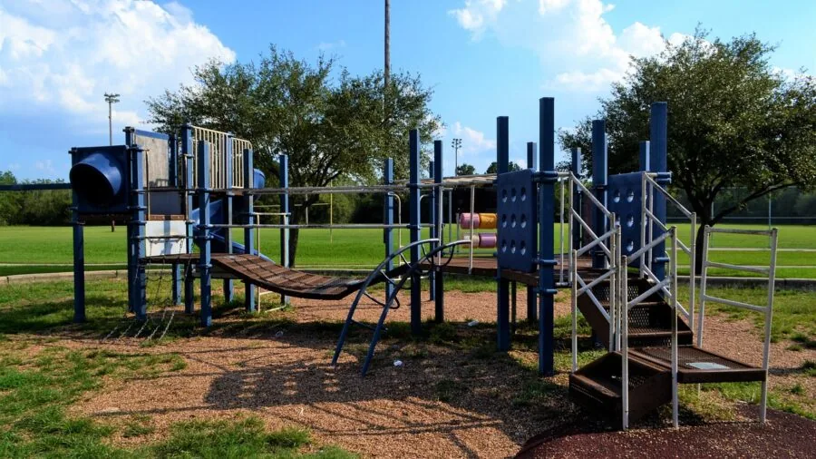 Child enjoying outdoor play in a sunny park with open space for recreational activities