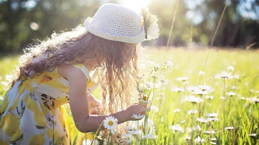 Child using instant camera outside, capturing moments with natural lighting and genuine candid expression