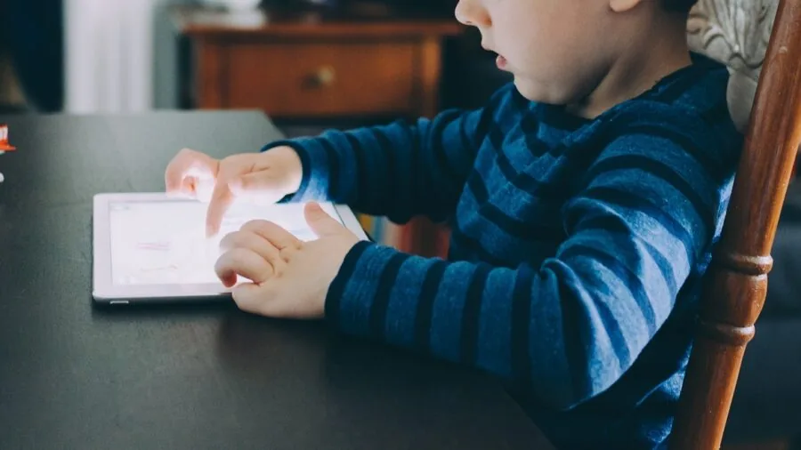 Child using tablet for educational content and games with downloaded apps and videos