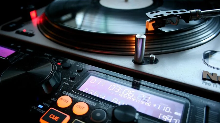Close-up of a turntable stylus touching a spinning vinyl record groove during playback
