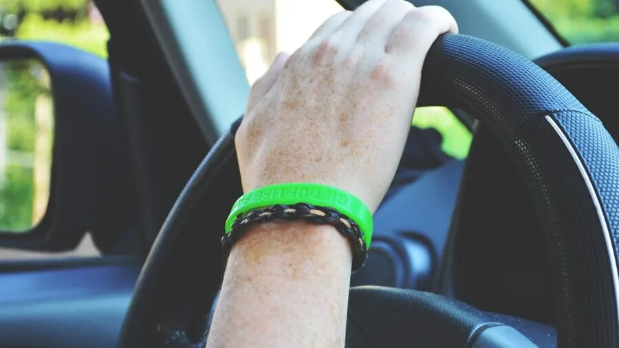 Close-up of driver's hands firmly gripping steering wheel during intense racing moment