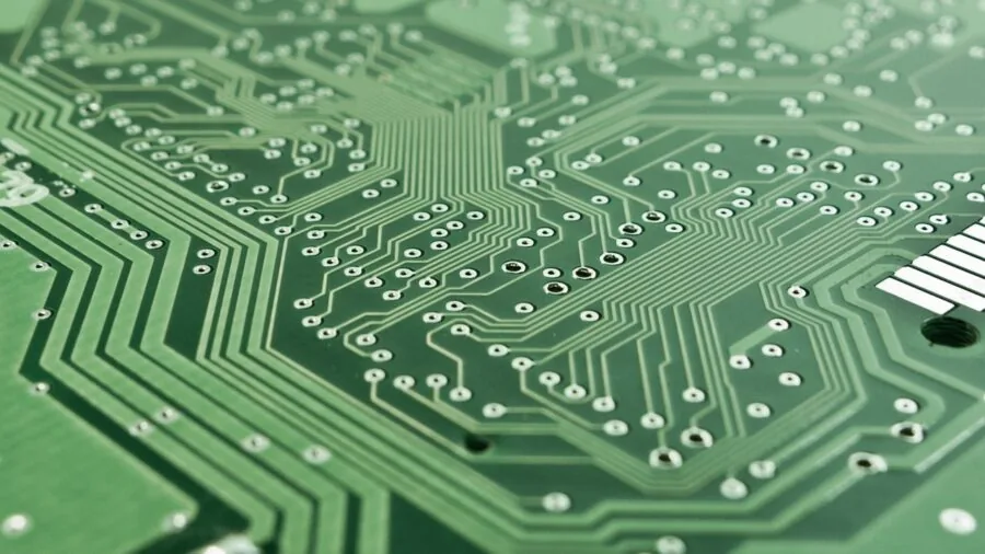 Close-up of engineer inspecting electronic circuit board components with precision tools