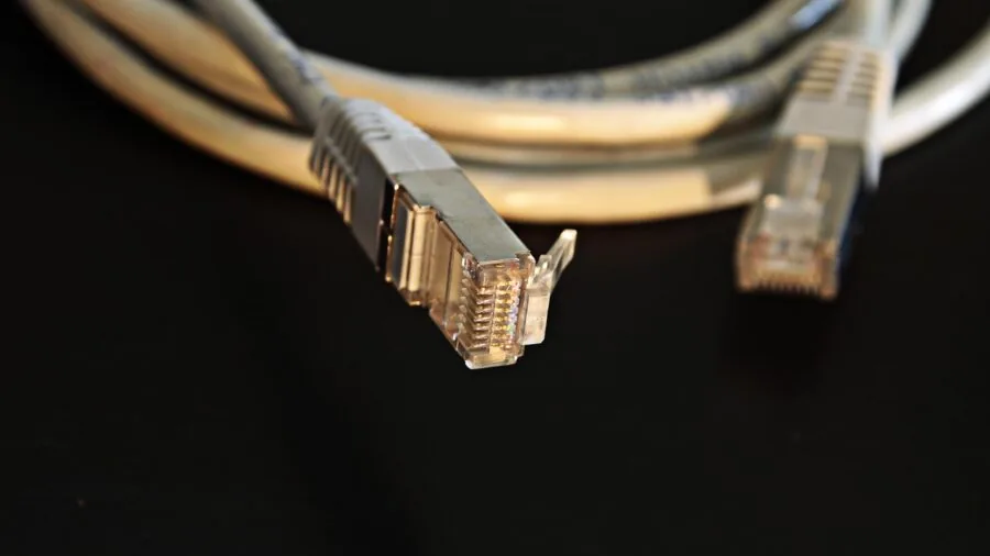 Close-up of ethernet cables connected to networking equipment with power delivery system