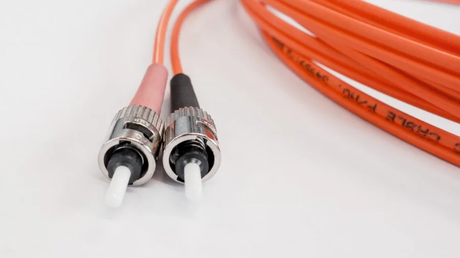 Close-up of fiber optic cables connected to networking equipment in a professional server setup