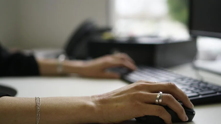 Close-up of hands typing on mechanical keyboard, showing tactile interaction and typing experience