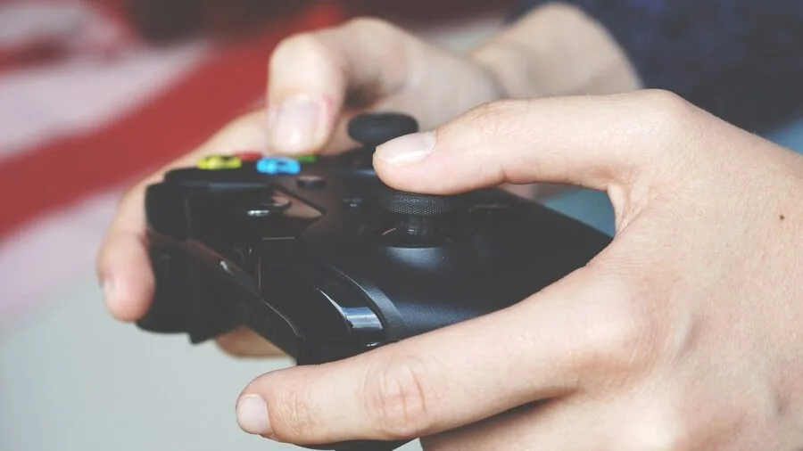 Close-up of hands using tactile control buttons during gaming session, showing practical headset operation