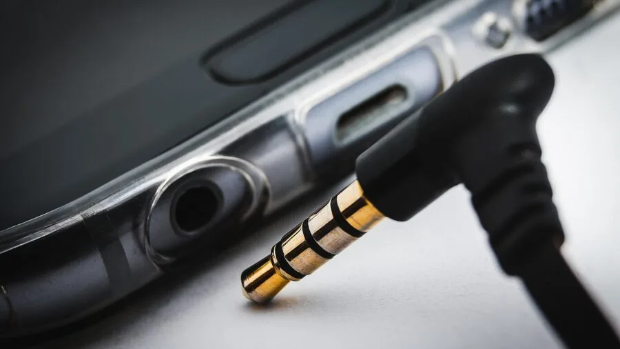 Close-up of someone plugging in a headphone cable connector during a recording or audio session