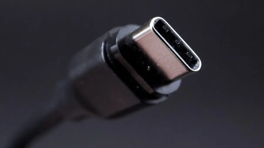 Close-up of various tech cables and USB ports connected to computer equipment on a desk