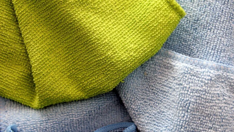Close-up view of carpet fibers with dust particles visible in natural lighting