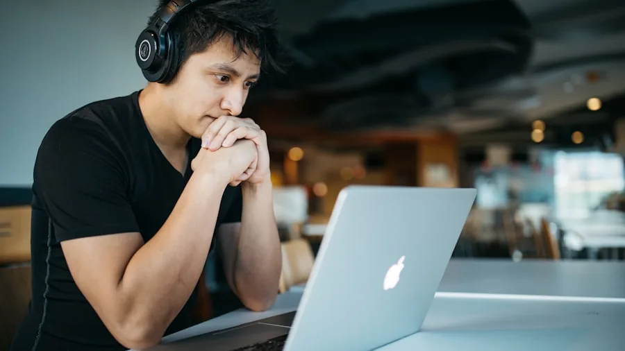 College student working on laptop during a long study session in a bright classroom or library setting