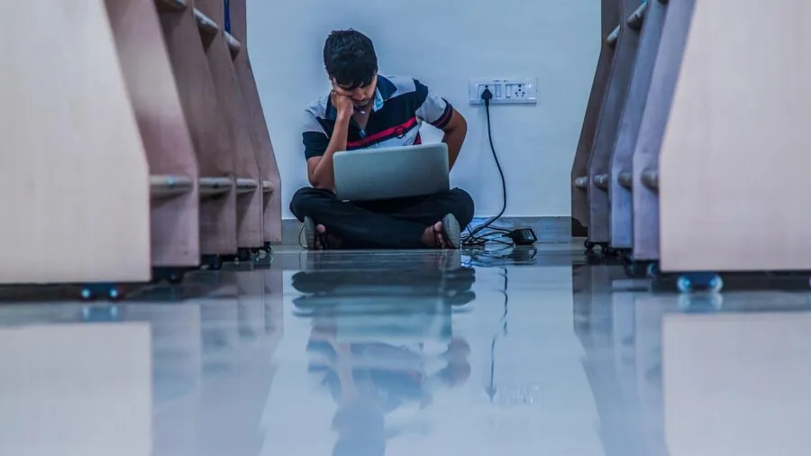 College student working on laptop in various positions showing device flexibility and adaptability