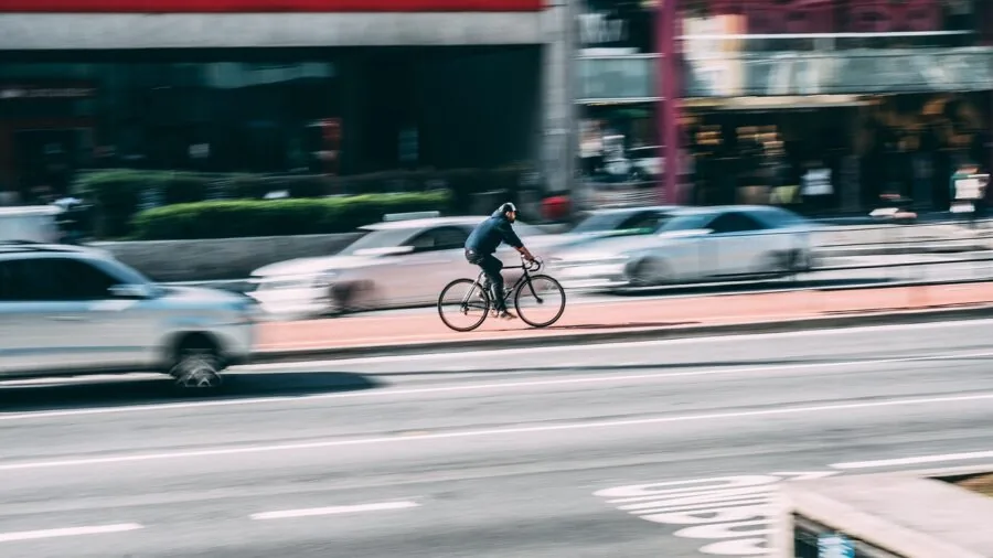 Commuter cyclist riding on city street while staying connected and focused on the road