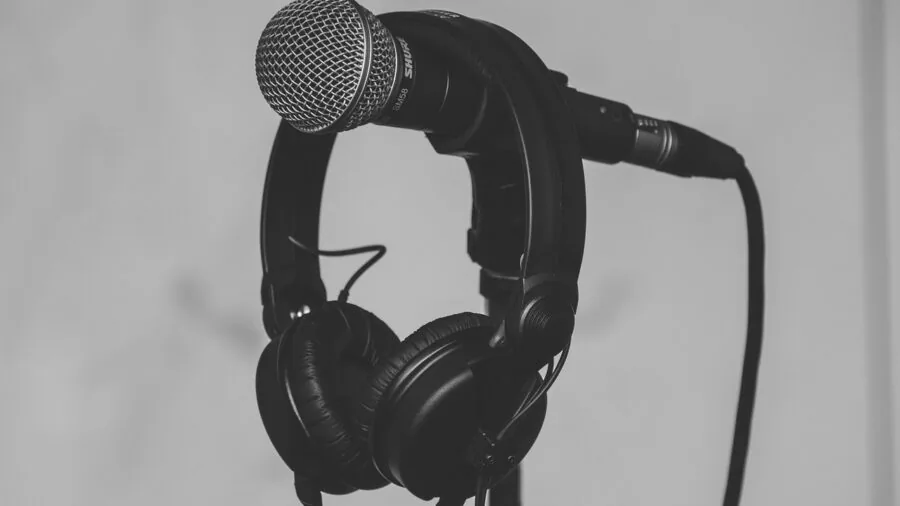 Content creator adjusting microphone levels while recording video in natural lighting