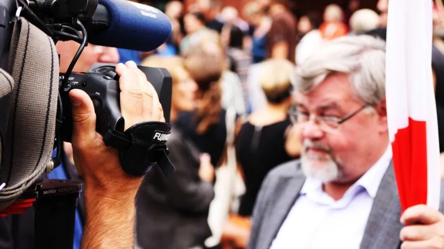 Content creator holding microphone while recording outdoors, demonstrating audio equipment for video production
