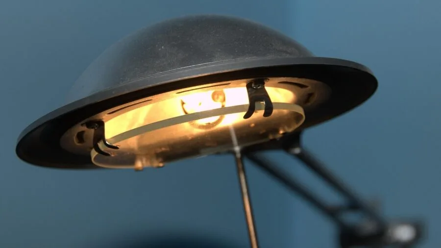 Content creator recording video at desk with warm desk lamp providing ambient lighting