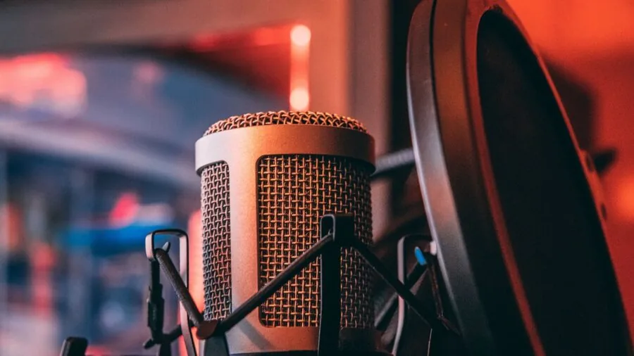 Content creator speaking into microphone in professional home studio setup