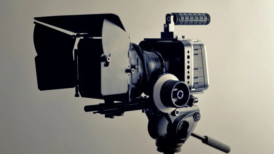 Content creator transferring video files wirelessly from camera to laptop in modern workspace