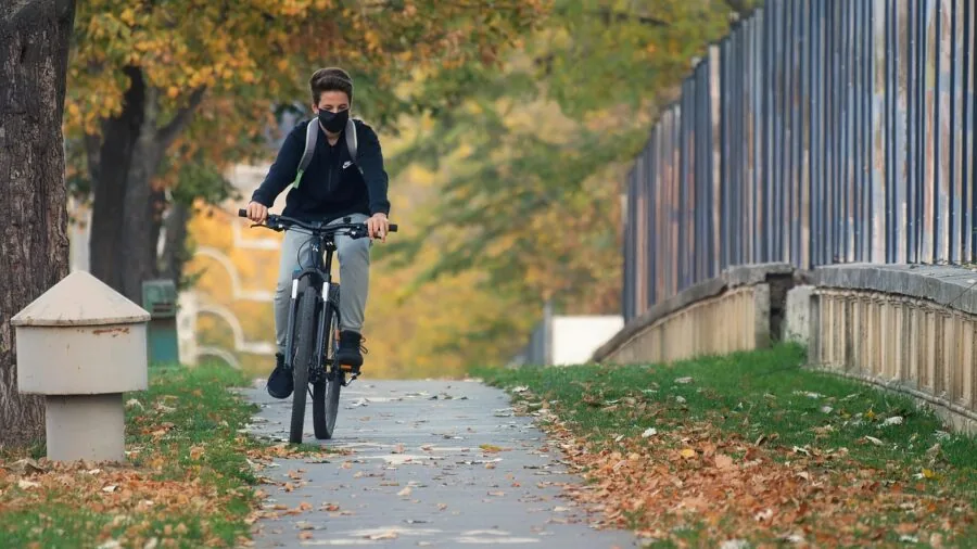 Cyclist riding on open road with awareness of surroundings and traffic environment