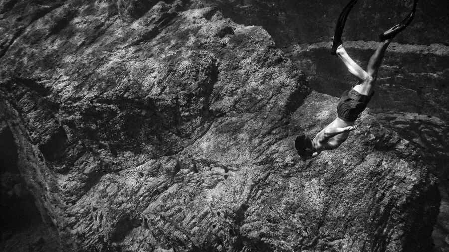 Diver exploring deep underwater environment with diminishing light and dark ocean depths