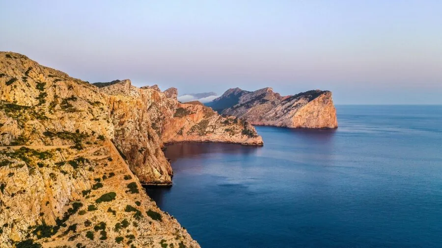 Filmmaker capturing scenic landscape with drone technology in outdoor environment
