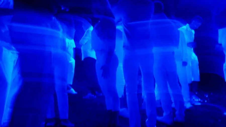 Group of friends dancing together at an outdoor summer party celebration