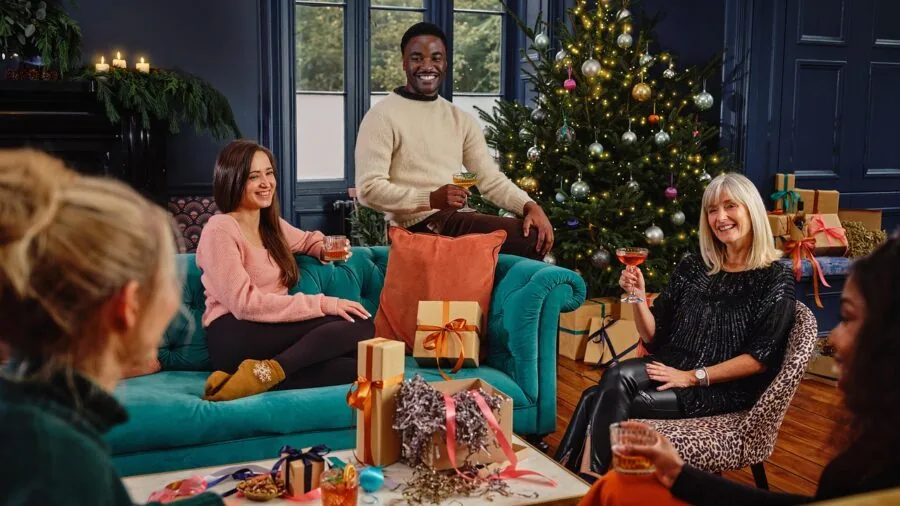 Group of people gathered in a living room watching sports on television together