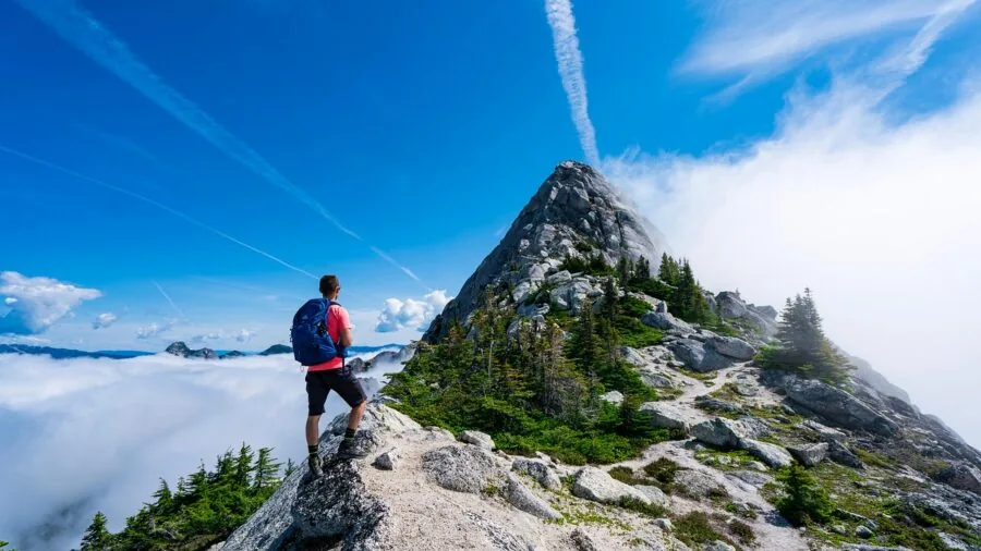 Hiker charging camera battery during outdoor adventure trip in natural landscape setting