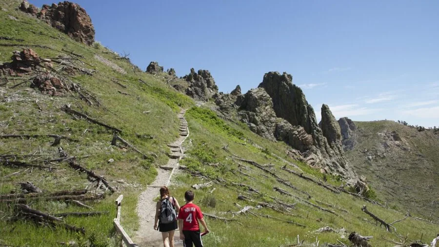 Hiker with backpack trekking through mountain wilderness on sunny day