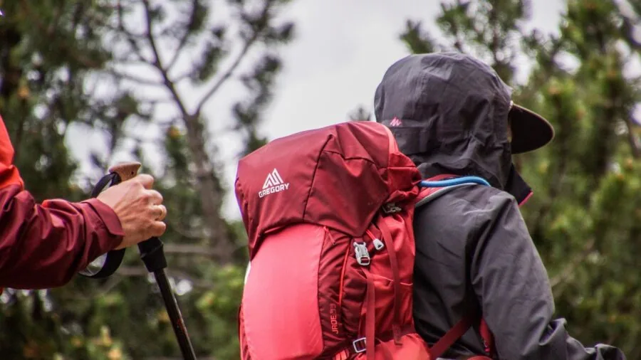 Hiker with light backpack walking on mountain trail during daytime