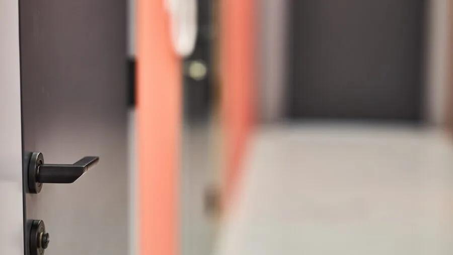 Homeowner installing a new deadbolt lock on front door frame