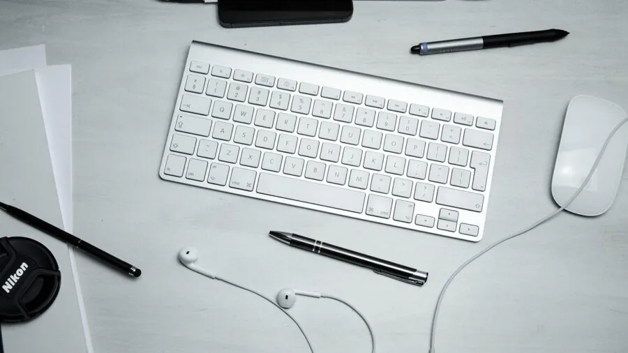 Minimalist desk workspace with compact keyboard and mouse, showing clean organized computer workstation
