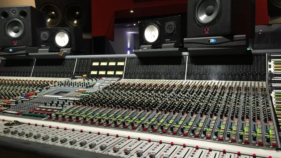 Music producer at work in professional recording studio with acoustic treatment and monitoring setup