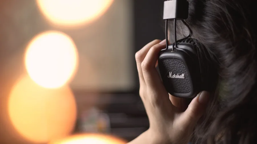 Music producer wearing over-ear headphones during long studio recording session