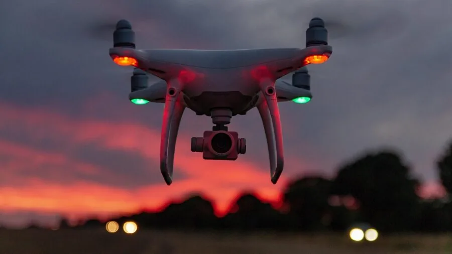 Operator flying drone over expansive landscape with clear sky for signal transmission