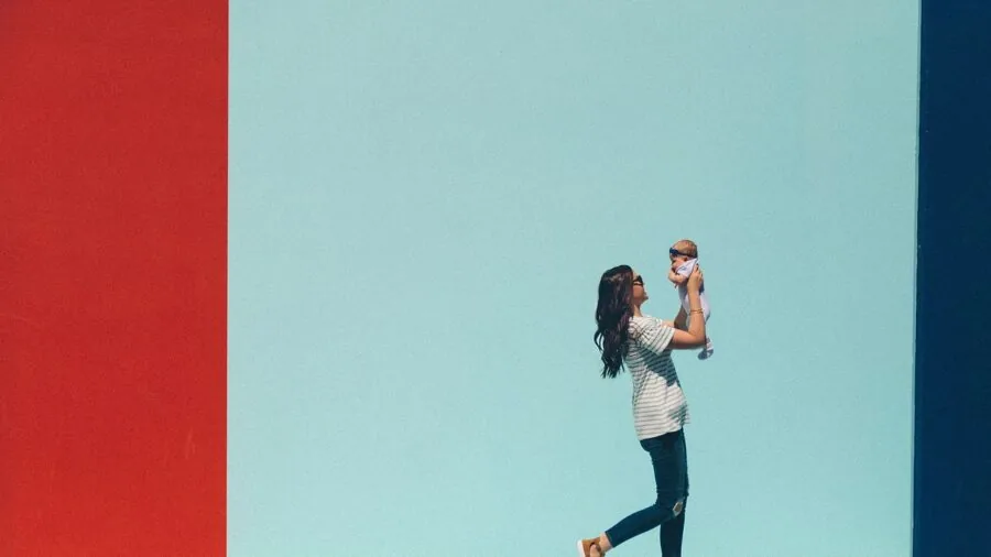 Parent monitoring baby on smartphone at home, representing modern parenting technology and connected home security