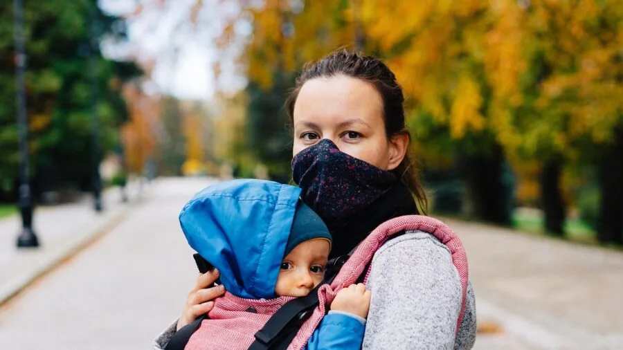 Parent watching child play outdoors in park, representing GPS safety monitoring for kids