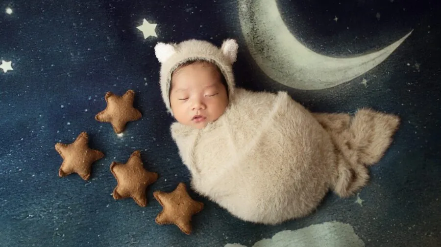 Parent watching over peacefully sleeping baby in dark nursery room at night