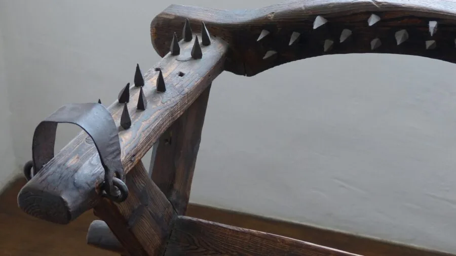 Person adjusting armrests on chair to maintain proper shoulder and back alignment while seated