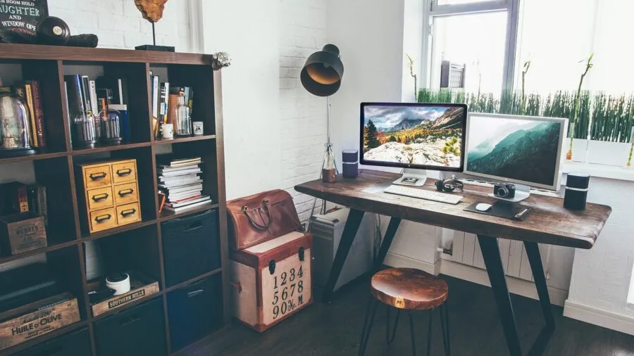 Person adjusting display settings on multiple computer monitors in a home entertainment setup