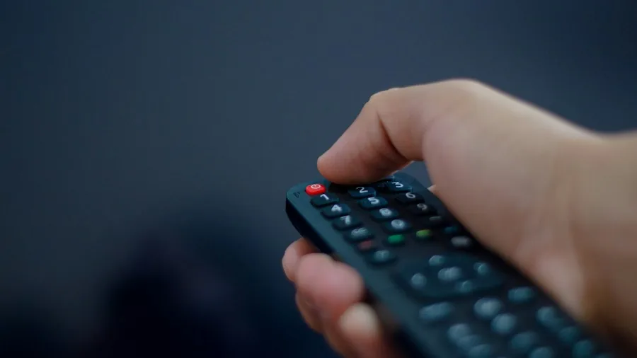 person adjusting smart TV settings on remote control