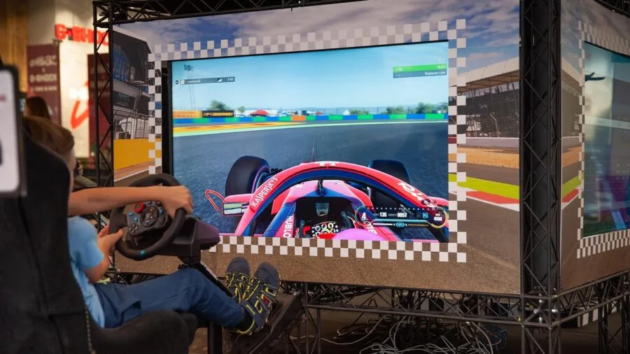 Person adjusting steering wheel position on racing simulator cockpit setup