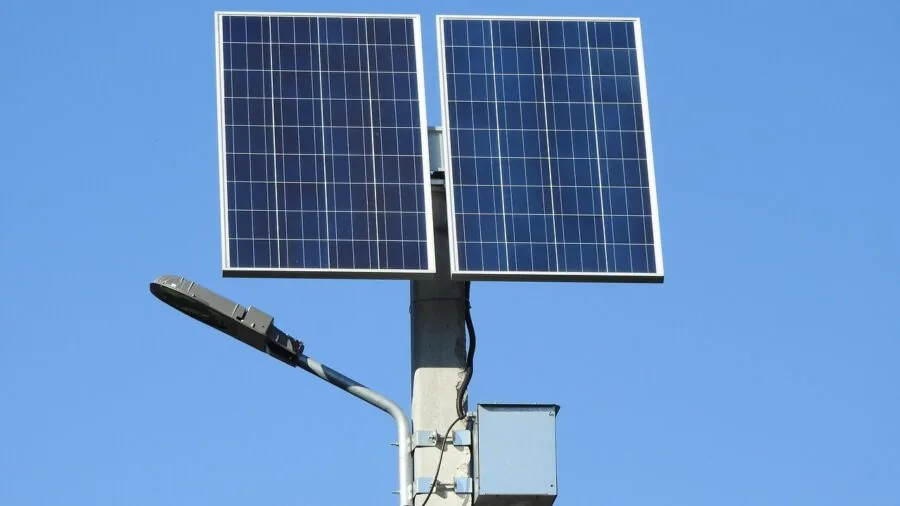 Person assembling modular solar power components in natural outdoor setting for sustainable energy