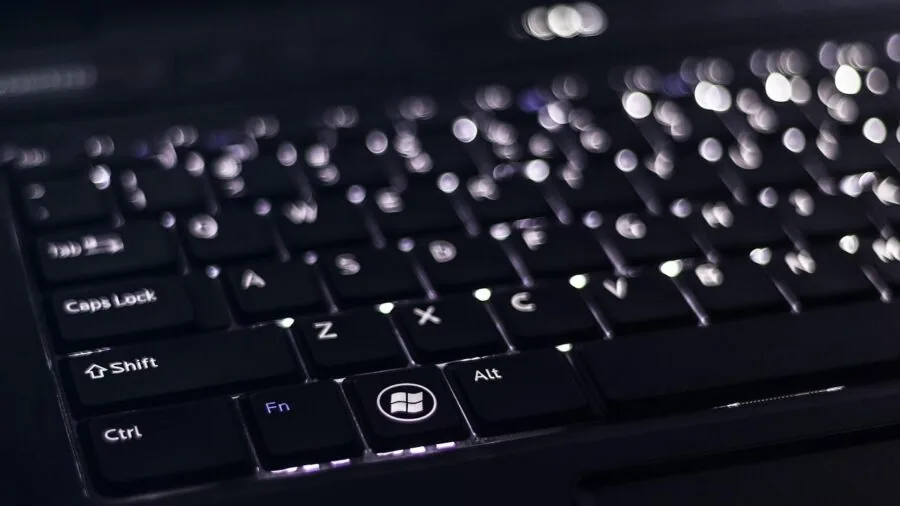 Person at desk connecting external devices to laptop with USB cables and peripherals