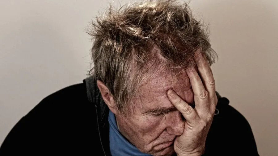 Person at home looking frustrated while checking internet service provider requirements on laptop